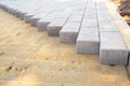 Paving slabs or paving stones are laid out on the sand. Process of building footpath. Landscaping, urban environment Royalty Free Stock Photo