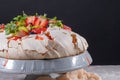 Pavlova cake with cream and fresh summer berries and kiwi on wooden background. Close up of Pavlova dessert with forest fruit and Royalty Free Stock Photo