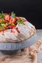 Pavlova cake with cream and fresh summer berries and kiwi on wooden background. Close up of Pavlova dessert with forest fruit and Royalty Free Stock Photo