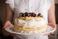 Pavlova cake with fresh cherry in the woman hands horizonta