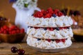 Pavlova cake of three layers of meringue, whipped cream and berries