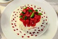Pavlova dessert with cream mint and strawberry in a white plate on a white table Royalty Free Stock Photo