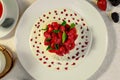 Pavlova dessert with cream mint and strawberry in a white plate on a white table Royalty Free Stock Photo