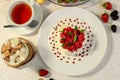 Pavlova dessert with cream mint and strawberry in a white plate on a white table Royalty Free Stock Photo