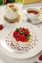 Pavlova dessert with cream mint and strawberry in a white plate on a white table Royalty Free Stock Photo
