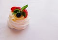 Pavlova mini cake with fruits and mint leaves.