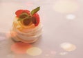 Pavlova mini cake with fruits and mint leaves in the stardust.