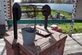 PAVLOVSK, RUSSIA - APRIL 23, 2017: the metal bucket is on the cover of this well with drinking water