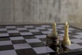 A pawn figure plays chess on a stack of coins against the background of a king figure. Royalty Free Stock Photo