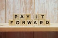 Pay It Forward alphabet letter on shelves wooden background Royalty Free Stock Photo