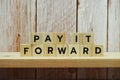 Pay It Forward alphabet letter on shelves wooden background Royalty Free Stock Photo