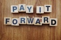 Pay It Forward alphabet letter on wooden background Royalty Free Stock Photo