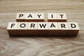 Pay It Forward alphabet letter on wooden background Royalty Free Stock Photo