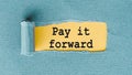 PAY IT FORWARD. Text written under ripped and torn paper Royalty Free Stock Photo
