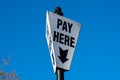 A pay here sign at.a parking site in Ironbridge in Shropshire, UK on a blue sky day Royalty Free Stock Photo