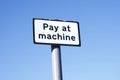 Pay at machine sign against empty blue sky Royalty Free Stock Photo