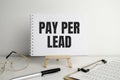 PAY PER LEAD text on white paper and glasses Royalty Free Stock Photo