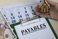 PAYABLES - word in a folder against the background of women`s hands with a house and money Royalty Free Stock Photo