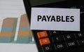 PAYABLES - word on a white sheet on the background of a black calculator and graph Royalty Free Stock Photo