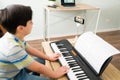 Paying attention to his online piano instructor Royalty Free Stock Photo