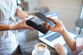 Paying by smartphone in coffee shop after coronavirus lockdown, hygiene concept. Royalty Free Stock Photo