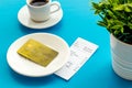Paying in restaurant. Bank card near cup of coffee on blue table Royalty Free Stock Photo