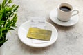 Paying in restaurant. Bank card near cup of coffee on grey table Royalty Free Stock Photo
