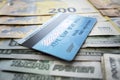 payment card on background of paper dollars. blue plastic multicurrency credit card is lying on stack of money euros rubles and