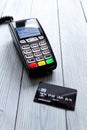 Payment card through terminal in store top view wooden background