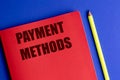 Payment methods text on red notebook with yellow pencil on blue background representing financial concept Royalty Free Stock Photo