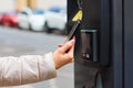 Payment for parking using contactless NFC technology supported Visa and Mastercard. Closeup womans hand using a Royalty Free Stock Photo
