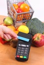 Payment terminal with contactless credit card and fruits and vegetables, cashless paying for shopping Royalty Free Stock Photo