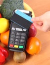 Payment terminal with contactless credit card and fruits and vegetables, cashless paying for shopping Royalty Free Stock Photo