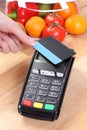Payment terminal with contactless credit card, fruits and vegetables, cashless paying for shopping Royalty Free Stock Photo