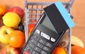 Payment terminal with contactless credit card, fruits and vegetables, concept of cashless paying for shopping Royalty Free Stock Photo