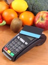 Payment terminal with contactless credit card, fruits and vegetables, concept of cashless paying for shopping Royalty Free Stock Photo