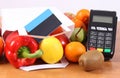 Payment terminal, contactless credit card, paper bag with fruits and vegetables Royalty Free Stock Photo