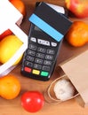 Payment terminal, contactless credit card, paper shopping bag with fruits and vegetables Royalty Free Stock Photo