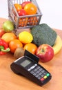 Payment terminal with credit card, fruits and vegetables. Cashless paying for shopping concept Royalty Free Stock Photo