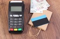 Payment terminal with credit card, polish money and paper shopping bag. Concept of cashless paying for shopping Royalty Free Stock Photo