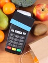 Payment terminal with contactless credit card, fruits and vegetables, cashless paying for shopping Royalty Free Stock Photo