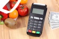 Payment terminal with currencies dollar, fruits and vegetables, cashless paying for shopping Royalty Free Stock Photo