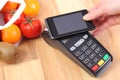 Payment terminal and mobile phone with NFC technology, fruits and vegetables, cashless paying for shopping Royalty Free Stock Photo