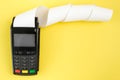 Payment terminal POS with a roll cash tape on the yellow background with copy space Royalty Free Stock Photo