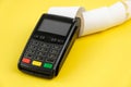 Payment terminal POS with a roll cash tape on the yellow background