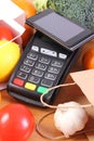 Payment terminal and smartphone with NFC technology, fruits and vegetables, cashless paying for shopping Royalty Free Stock Photo