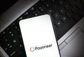 Payoneer logo displayed on smartphone screen on laptop keyboard illustrative editorial technology finance Royalty Free Stock Photo