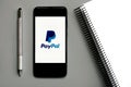 Paypal logo on black screen of smartphone with gray pen Royalty Free Stock Photo