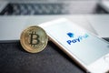 PayPal logo on a screen smartphone with bitcoin cryptocurrency