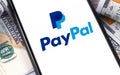 PayPal logo on the screen smartphone dollars Royalty Free Stock Photo